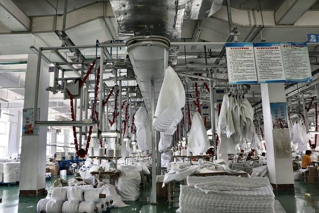 CleverMax hanger system with overhead buffer storage rails on a garment factory production line